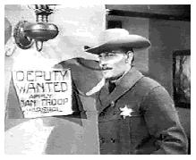 Dan hangs a deputy wanted sign