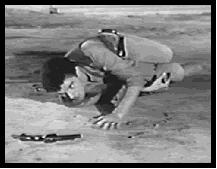 Jimmy tries to reach the gun that was shot out of his hand