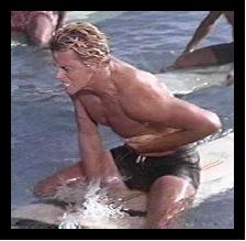 Chase [Peter  Brown] on a surf board in Ride the Wild Surf